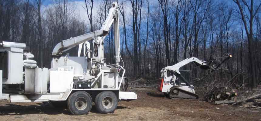 Environmental Tree Service trucks on site during a multi-acre land clearing job